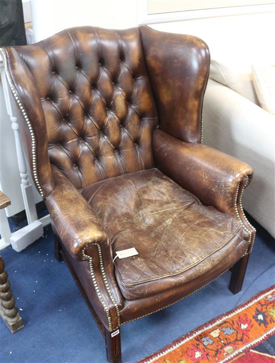 A brown leather wing armchair